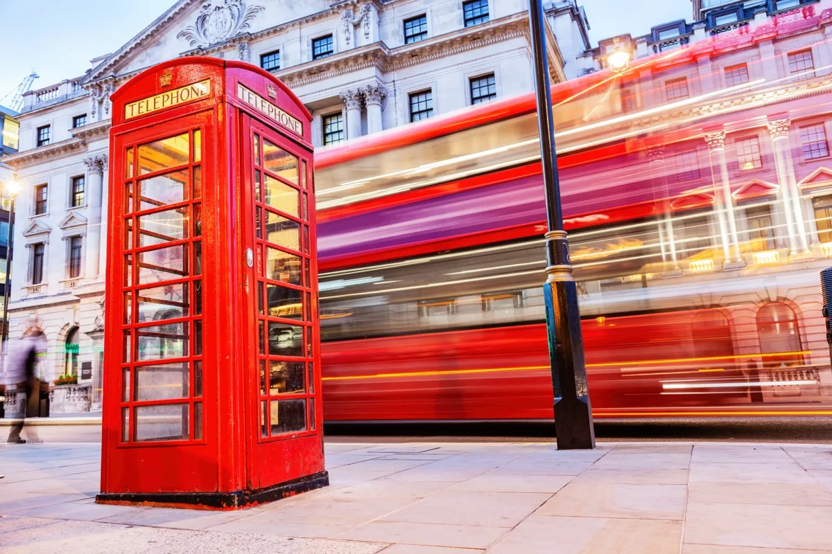 A red phone box and red bus on a London street
